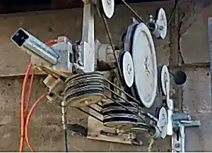 Diamond wire sawing machine mounted on wall, showcasing pulleys and drive system for precise concrete cutting applications.