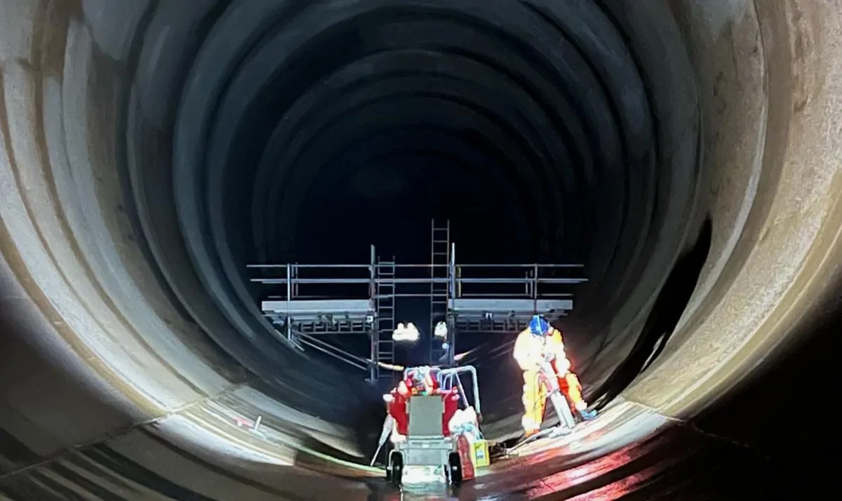 Workers operating diamond core drilling equipment inside a large tunnel, showcasing National Drilling Services' expertise in concrete cutting techniques.