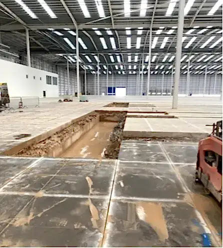 Concrete cutting project site showing excavated trench in large industrial space, highlighting National Drilling Services' expertise in efficient construction solutions.