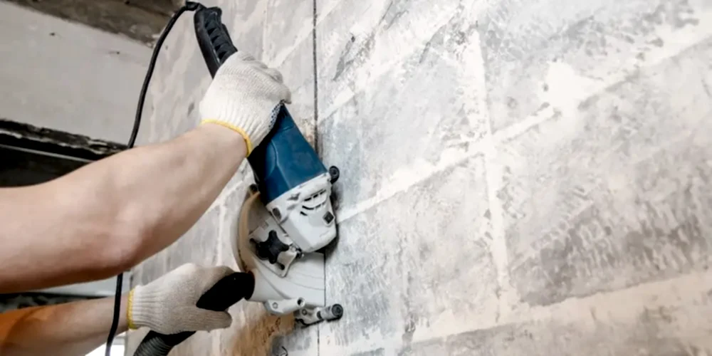 Person using a concrete wall cutter for precision drilling in construction, demonstrating diamond core drilling techniques.
