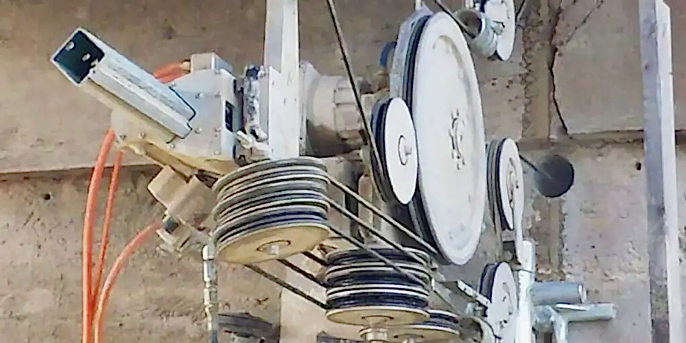 Wire sawing equipment with pulleys and motor, used for precision cutting in diamond core drilling services.